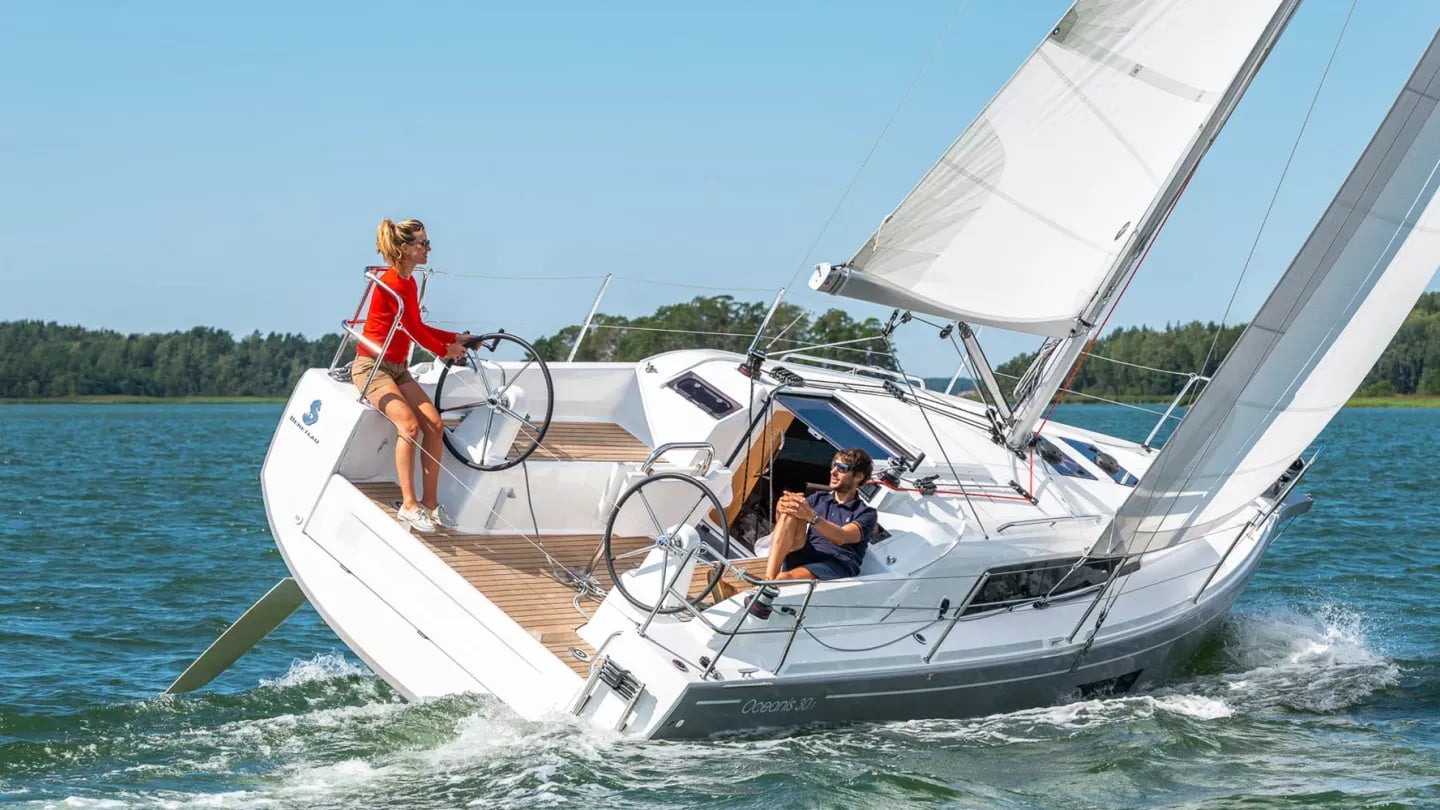 Le voilier Oceanis 30.1 MINUSCULE en navigation avec son équipage à la barre Le voilier Oceanis 30.1 MINUSCULE en navigation avec son équipage à la barre
