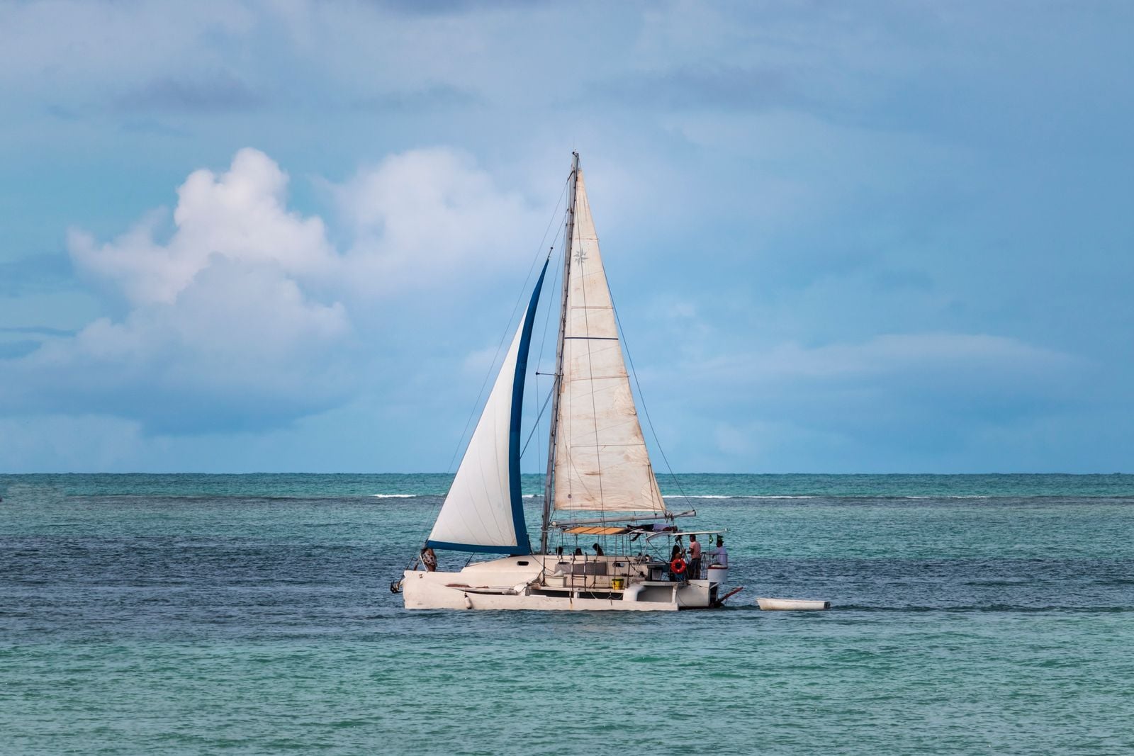 Catamaran naviguant sous voiles sur une mer calme Catamaran naviguant sous voiles sur une mer calme